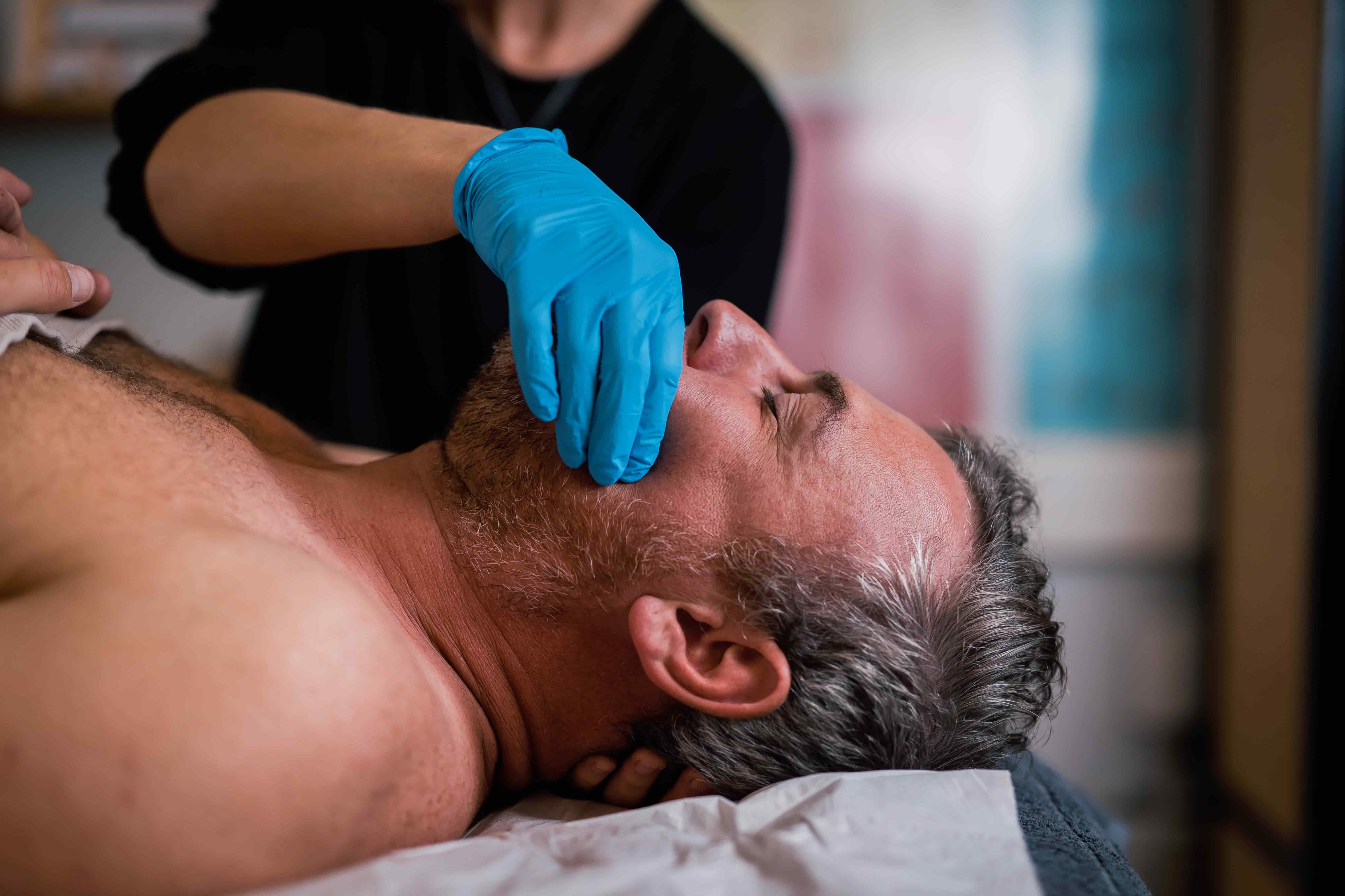 woman massaging a mans jaw